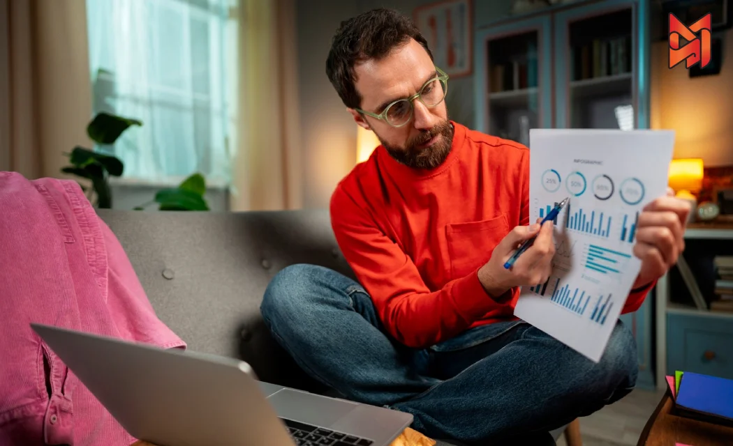 A performance marketer analyzing campaign data on a paper in his home.