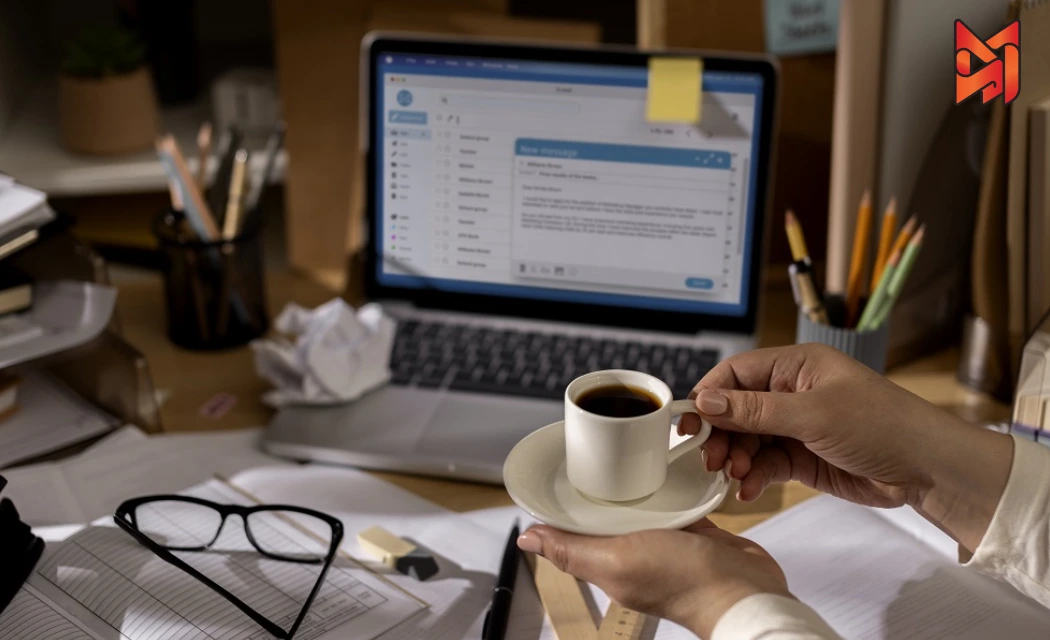 A marketer using email marketing software on a laptop, setting up an automated cold outreach campaign.