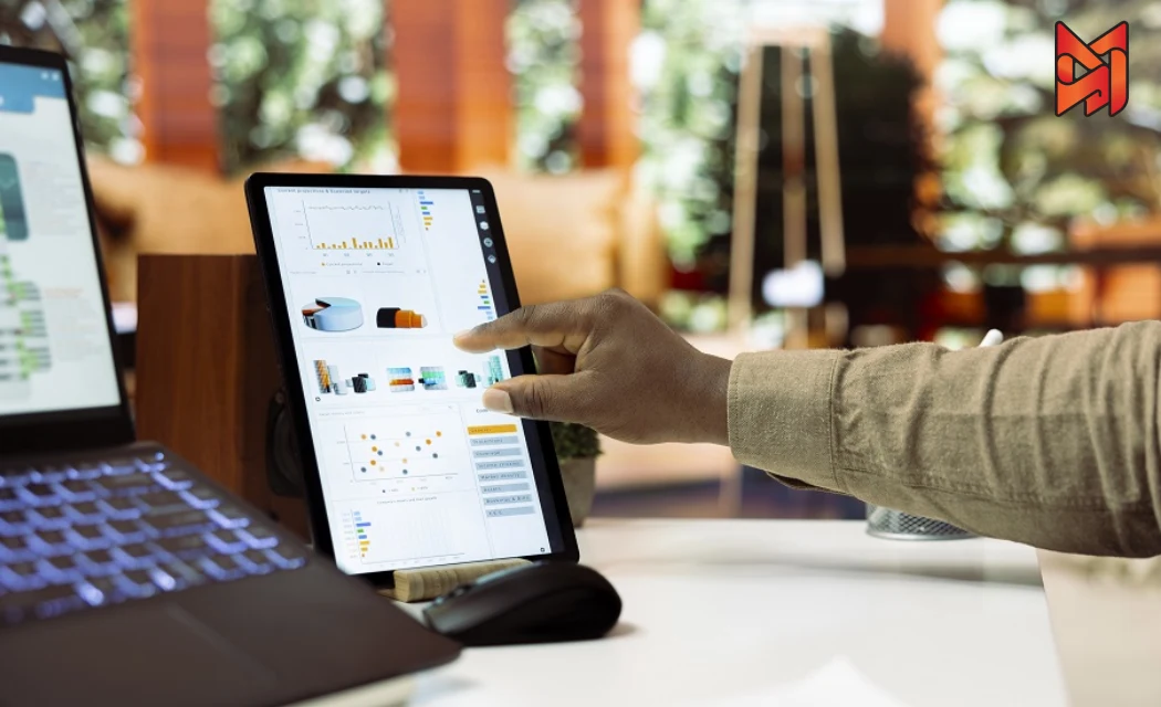 A digital marketing expert working on CRO strategies with mobile analytics and performance graphs on a tablet.