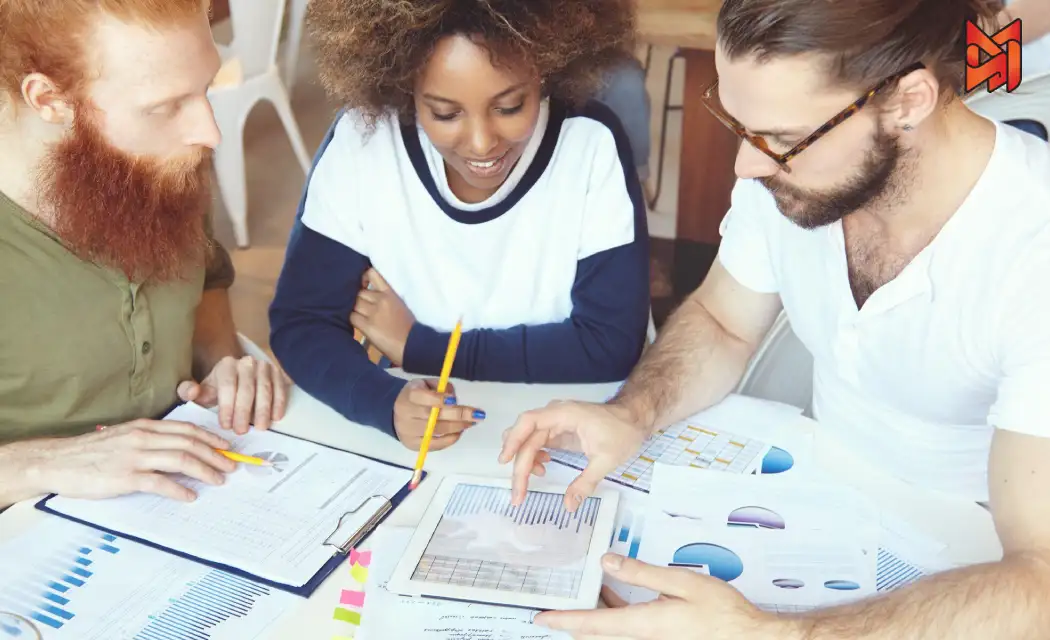 Digital marketers reviewing keyword trends and search volume statistics in a business meeting.