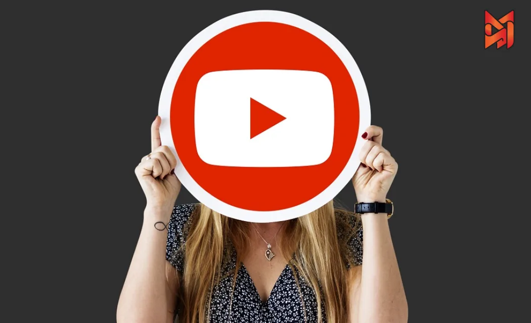 A woman concealing her face with a oversized YouTube play button, representing the influence of YouTube marketing.