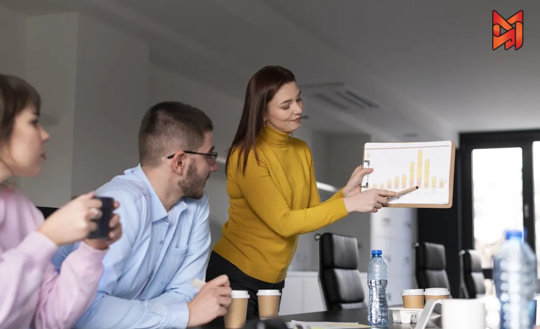 Group brainstorming growth strategies, analyzing charts to boost business performance.