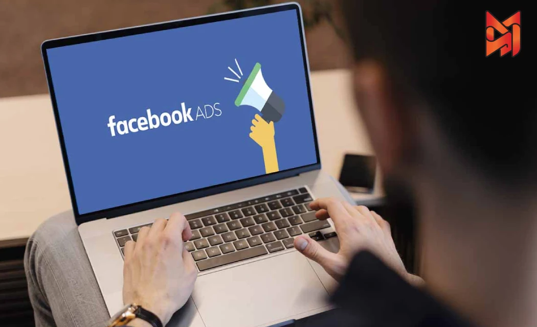 A PPC manager with a laptop uses effective ways to craft Facebook ad copy.